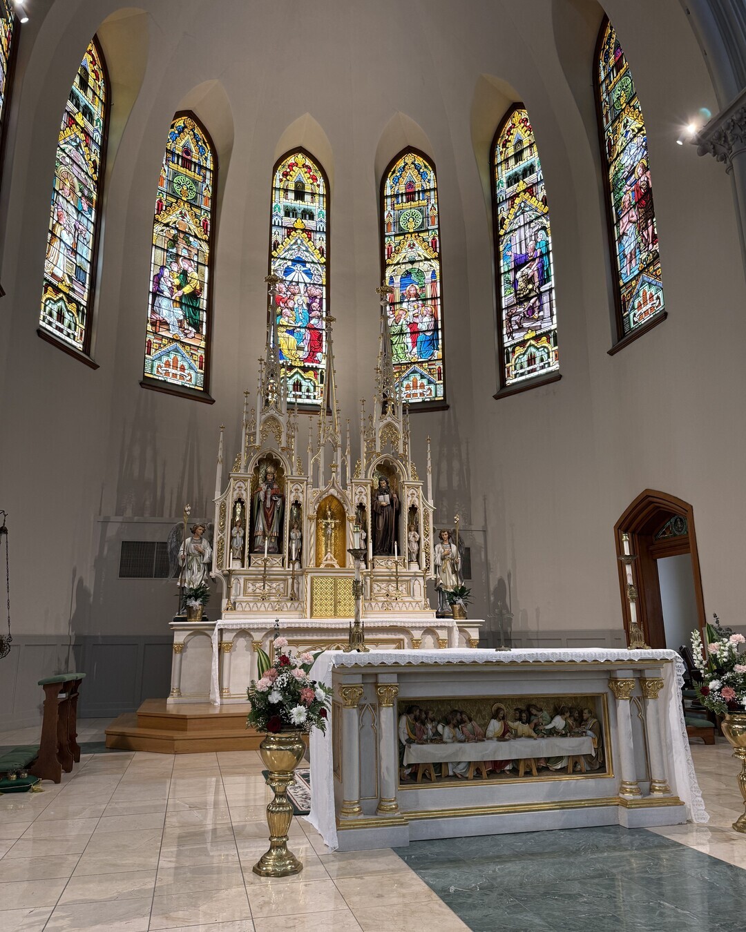 The full length of St. Patrick’s nave seen from the sanctuary, its vaulted ceiling leading to the stained-glass window and organ loft at the rear.